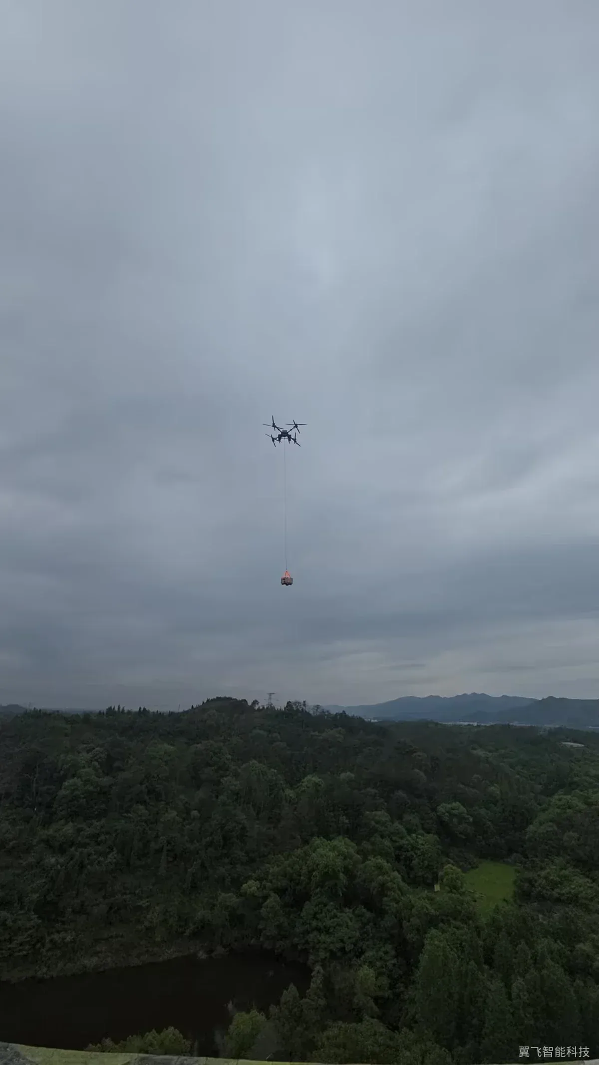 无人机吊挂物资穿越林间画面